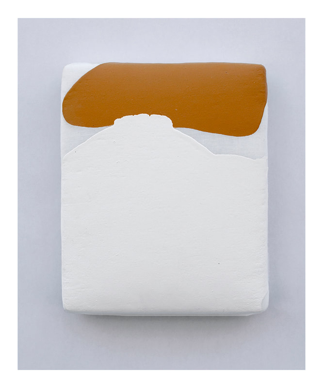 An upholstered, small vertical painting with an ochre upper third and a thick white lower two thirds. Rounded edges and a marshmallowy appearance, soft and rounded.